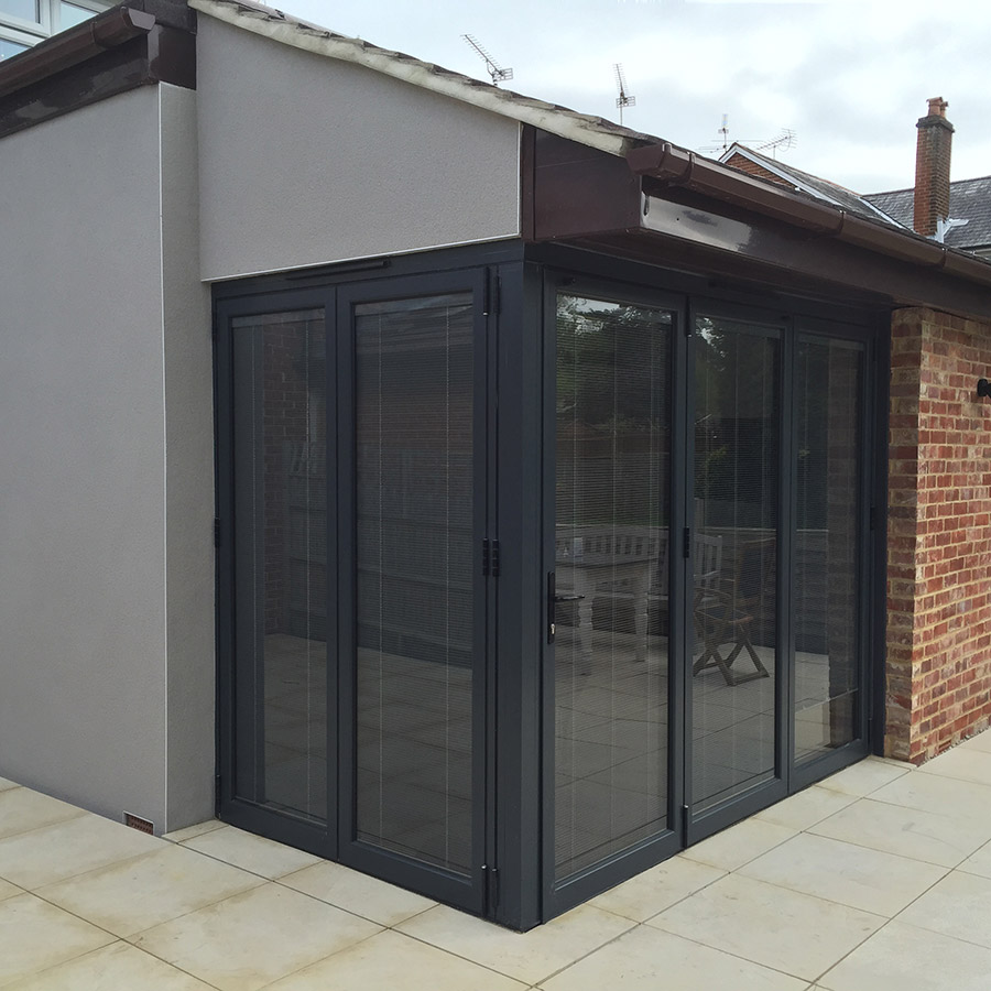 Anthracite grey aluminium bi-folding doors, floating corner.